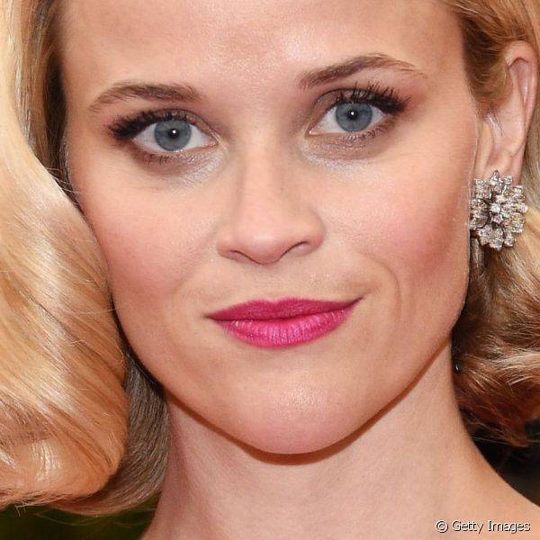 Reese Witherspoon usou um rosa vibrante nos lábios para fazer dobradinha com a cor do vestido e nos olhos um esfumado marrom equilibrou a make